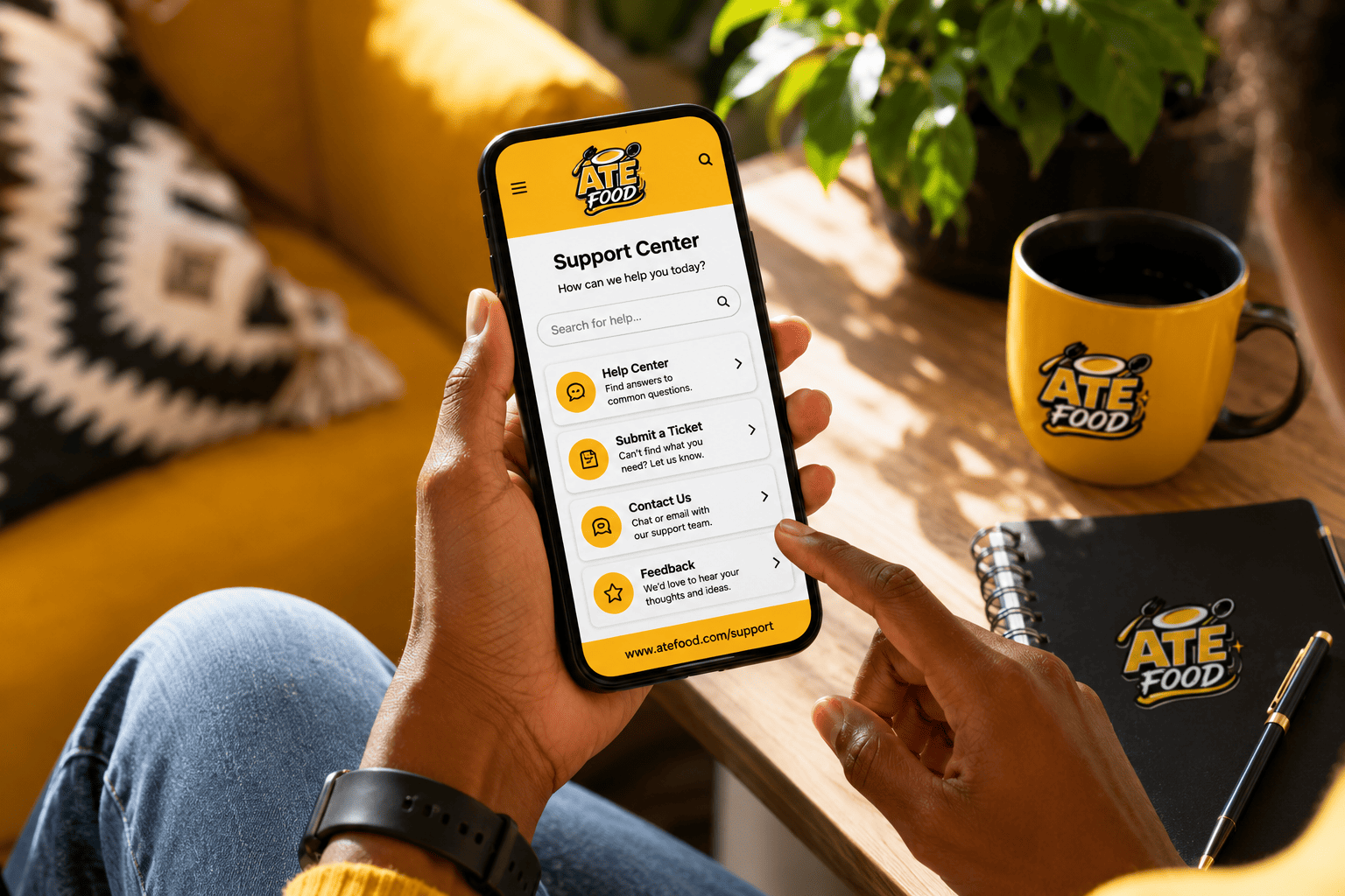 ATE Food support center displayed on a phone beside a branded mug and support notes